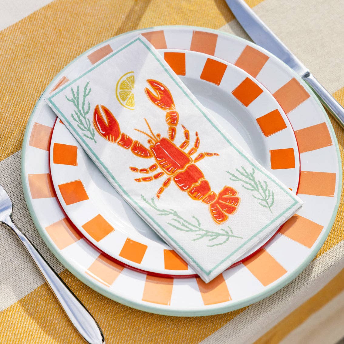 Servietter med hummermotiv brettet på dekket sommerbord